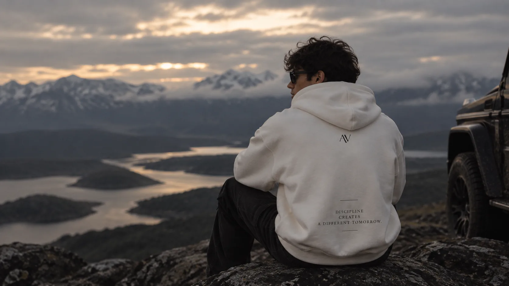Modelo con la Dual Zip Hoodie off white frente al paisaje al atardecer