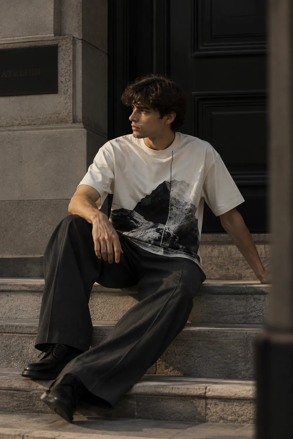 Modelo sentado con la Perspective T-Shirt off white